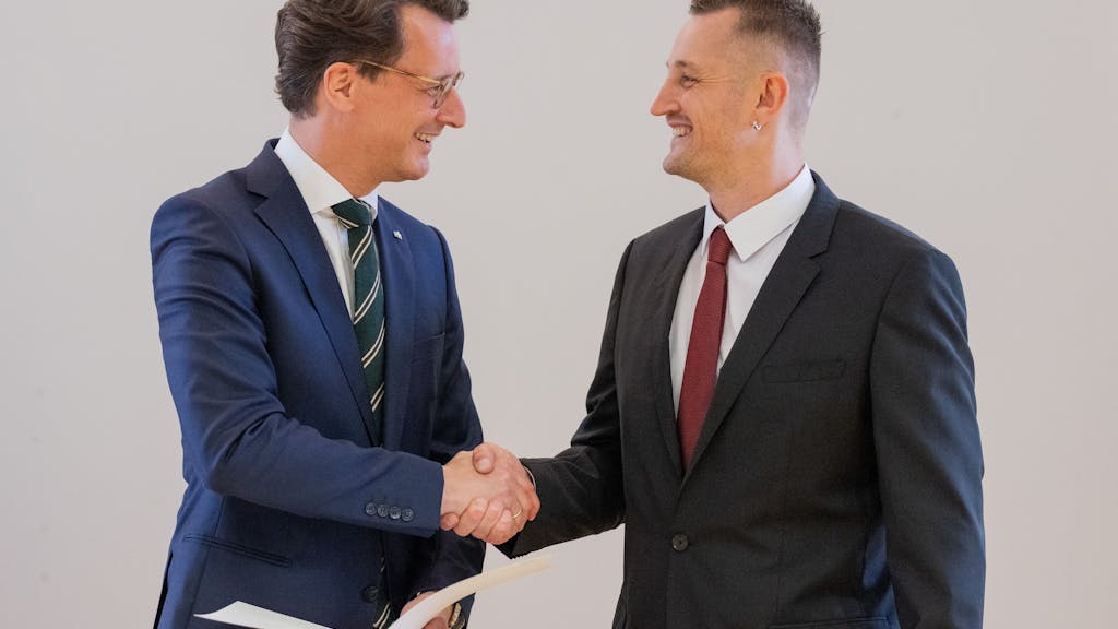 Hendrik Wüst (l, CDU), Ministerpräsident von Nordrhein-Westfalen, überreicht dem Lebensretter Dustin Raatz die Rettungsmedaille des Landes Nordrhein-Westfalen.