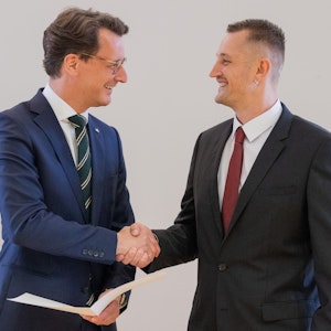 Hendrik Wüst (l, CDU), Ministerpräsident von Nordrhein-Westfalen, überreicht dem Lebensretter Dustin Raatz die Rettungsmedaille des Landes Nordrhein-Westfalen.