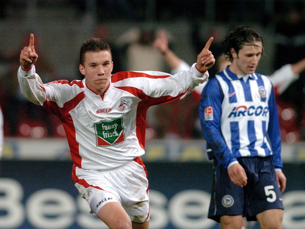 Lukas Podolski jubelt, indem er mit beiden Zeigefingern in den Himmel zeigt. Im Hintergrund steht der niedergeschlagene Niko Kovac.