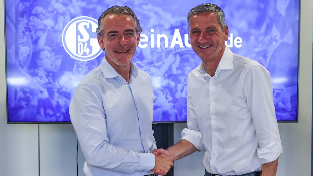 Schalkes Vorstandsvorsitzender Bernd Schröder und MeinAuto.de-Geschäftsführer Rudolf Rizzolli schütteln sich die Hand.