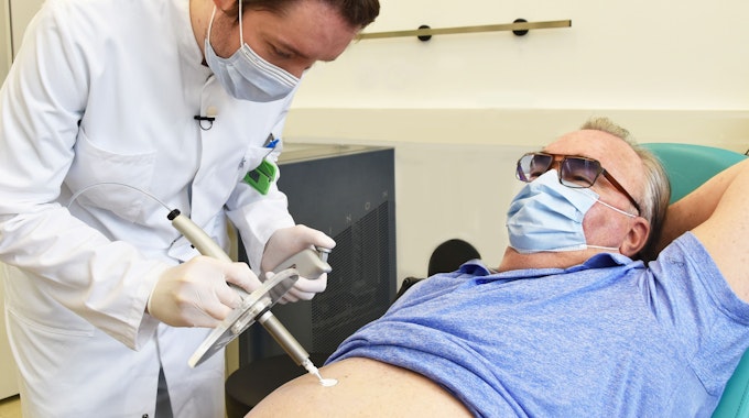 Nuklearmediziner Martin Heuschkel trägt radioaktive Paste beim Patienten Rainer Schnabel auf, die einen Hautkrebs-Tumor abtöten soll.