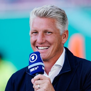 Bastian Schweinsteiger, TV-Experte der ARD, lacht mit einem Mikrofon in der Hand.