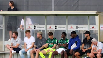 Prominent besetzte Zuschauerbank, mit unter anderem Ramy Bensebaini (2. v. r.) und Luca Netz (2. v. l.) im Rahmen des Testspiels zwischen Borussia Mönchengladbach und Viktoria Köln am 13. Juli 2022.