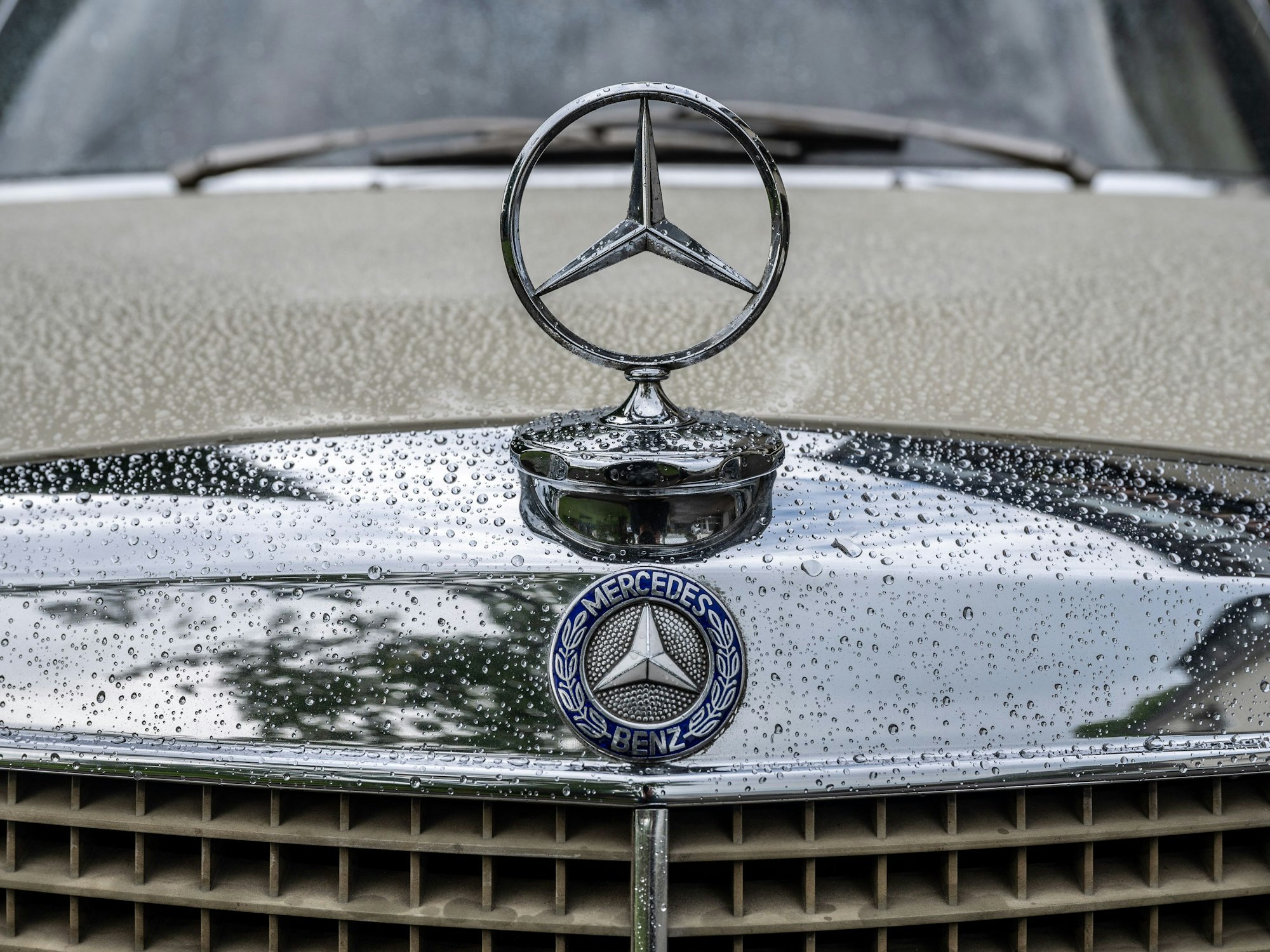 Der Mercedes-Stern eines Oldtimers ist zu sehen.