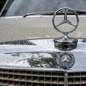 Der Mercedes-Stern eines Oldtimers ist zu sehen.