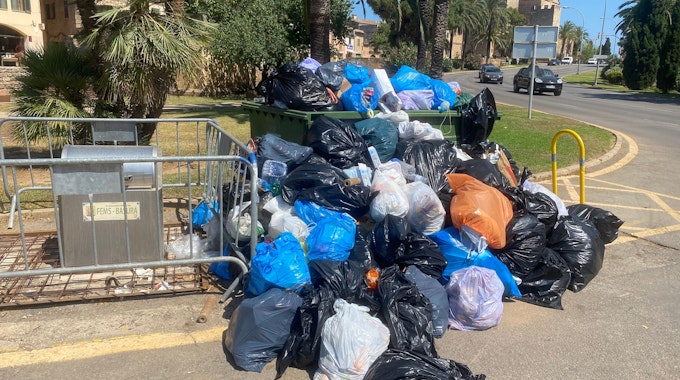 Sich stapelnde Müllsäcke vor einer überfüllten Mülltonne in Port d'Alcúdia auf Mallorca am 14. Juli 2022.
