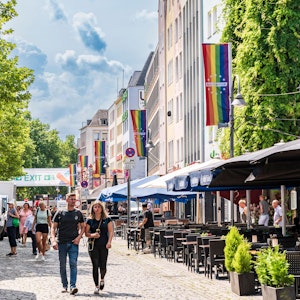 Menschen gehen durch die Kölner Altstadt kurz vor dem Christopher Street Day.