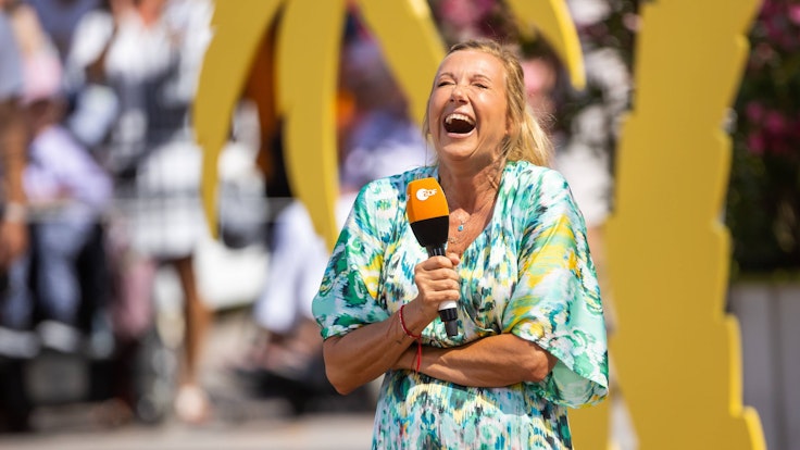 Andrea Kiewel lacht bei der Moderation des ZDF-„Fernsehgarten“.