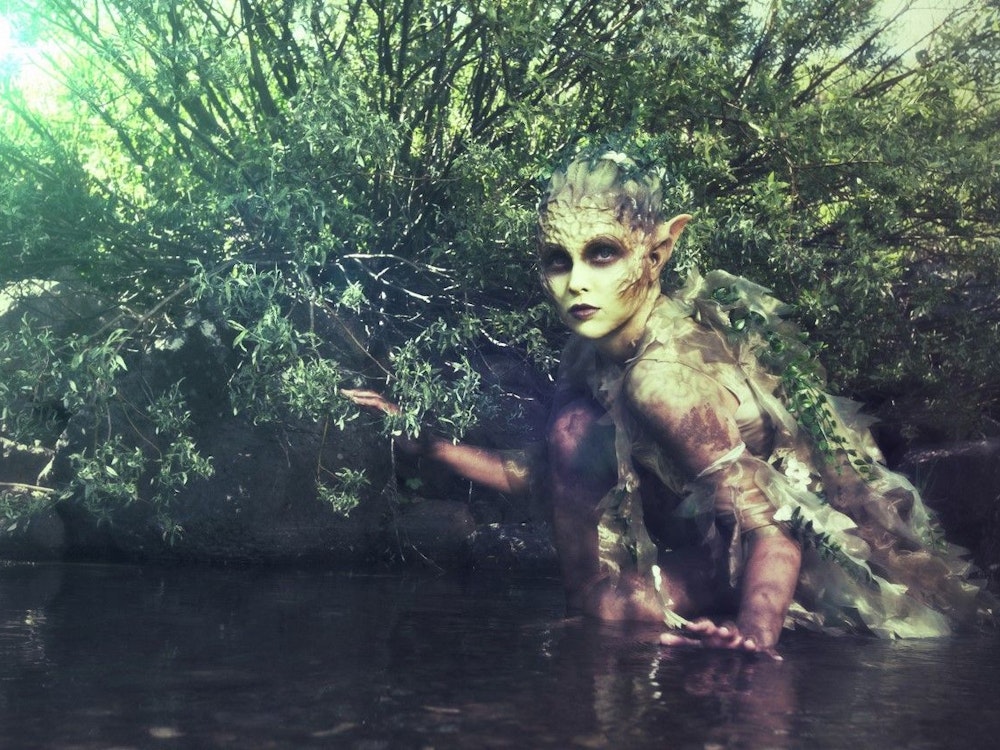 Eine Nymphe/Elfe versteckt sich in einem Fluss.