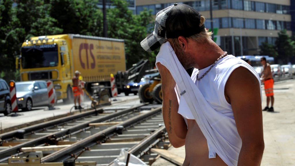 Ein Straßenarbeiter wischt sich am Montag (12.07.2010) in der Grillparzerstraße im Stadtteil Haidhausen in München (Oberbayern) bei großer Hitze den Schweiß ab.&nbsp;