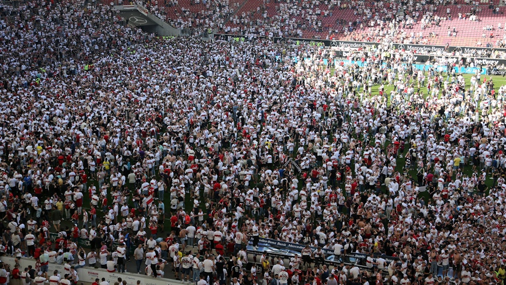 Hunderte VfB-Fans stehen auf dem Spielfeld nach Abpfiff.