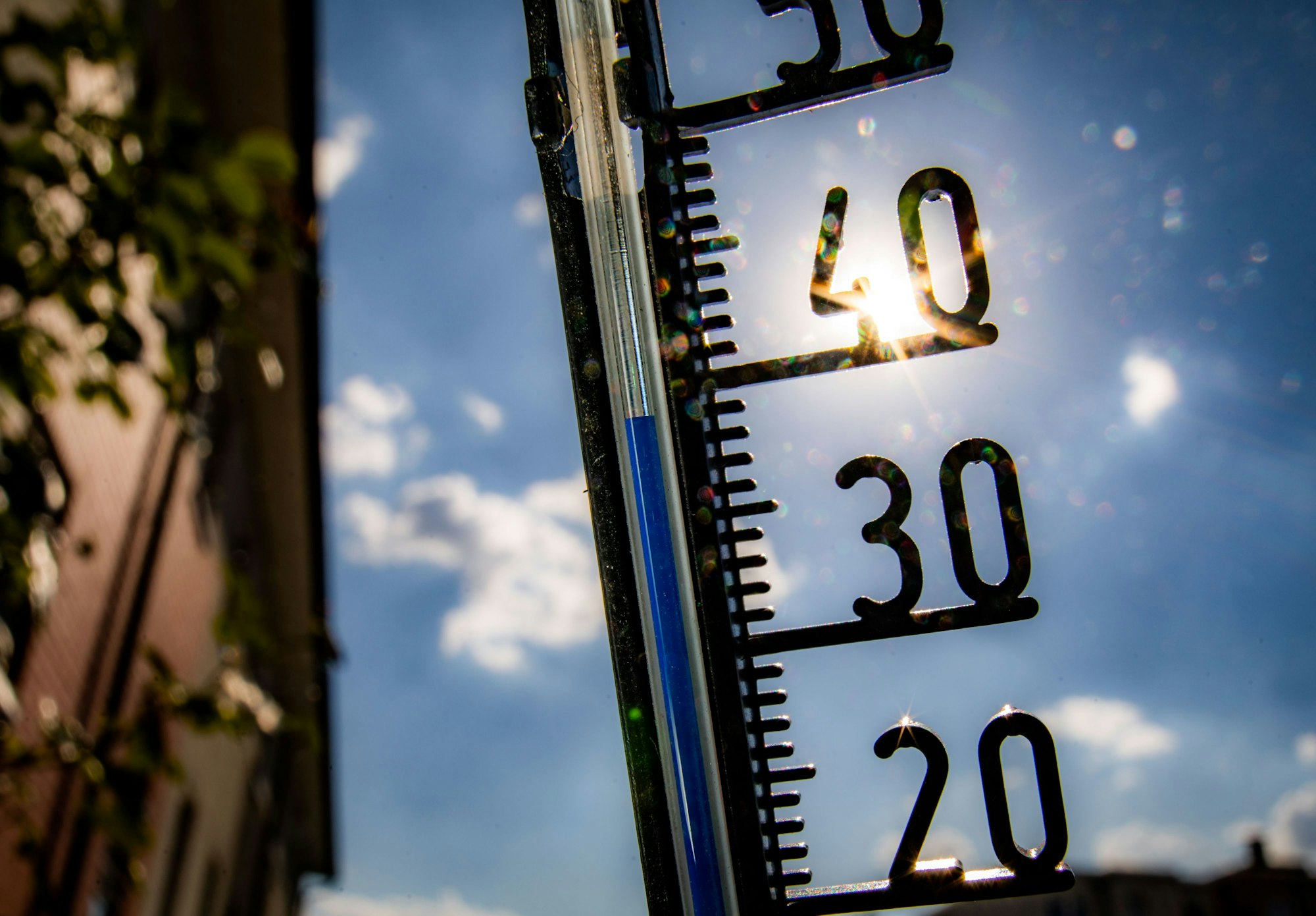 Ein Thermometer an einer Hauswand zeigt Temparaturen in Richtung der 40-Grad-Marke an.