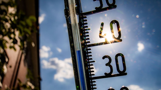 Ein Thermometer an einer Hauswand zeigt Temperaturen in Richtung der 40-Grad-Marke an.