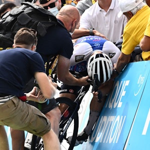 Fabio Jakobsen sackt nach seinem harten Kampf gegen die Uhr bei der 17. Etappe der Tour de France im Ziel in Peyragudes auf seinem Rad zusammen.