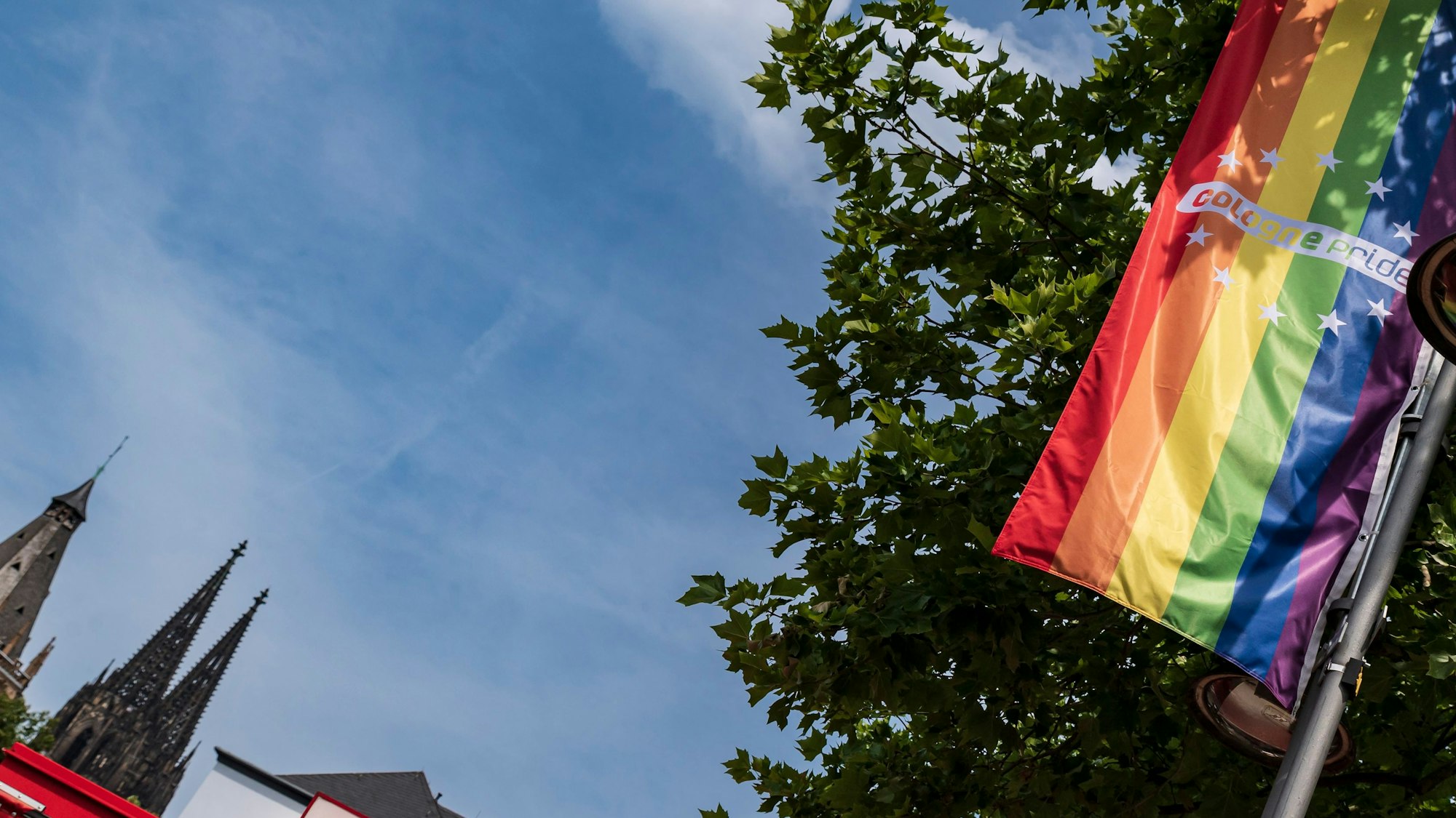 Eine Regenbogenflagge hängt an einem Fahnenmast in Köln.