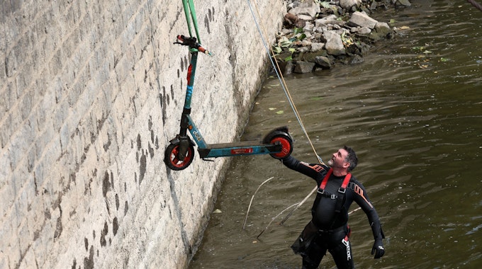 Christian Stock von Krake hat einen E-Scooter aus dem Rhein geborgen, der an einem Seil nach oben gezogen wird.