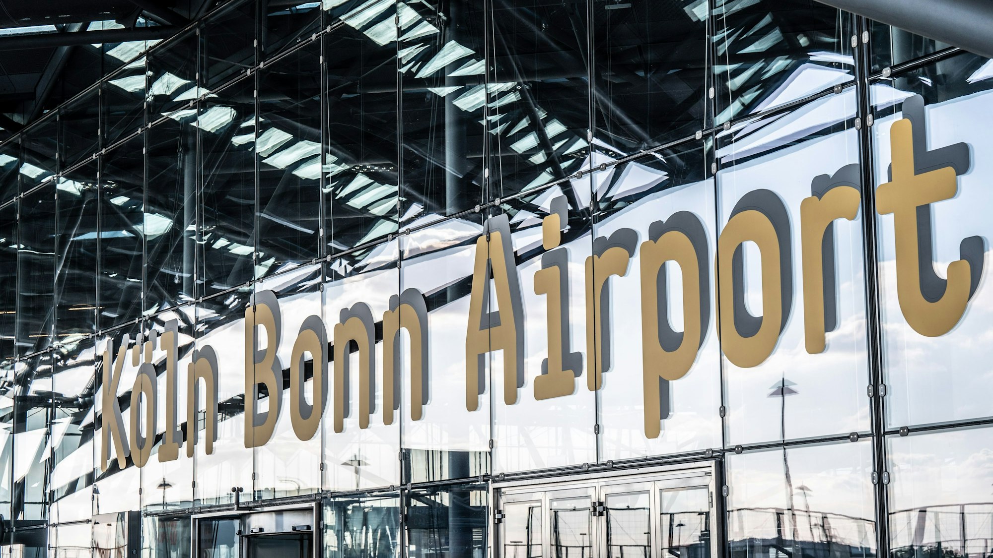 An einer gläsernen Fassade steht der Schriftzug Köln Bonn Airport.