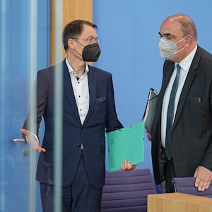 Karl Lauterbach (SPD), Bundesminister für Gesundheit, und Lars Schaade (r), Vizepräsident des Robert Koch-Instituts (RKI), im Gespräch nach bei einer Pressekonferenz zur Corona-Lage im Sommer in der Bundespressekonferenz.