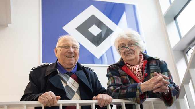 Uwe Seeler und seine Frau Ilka vor dem Logo des Hamburger SV