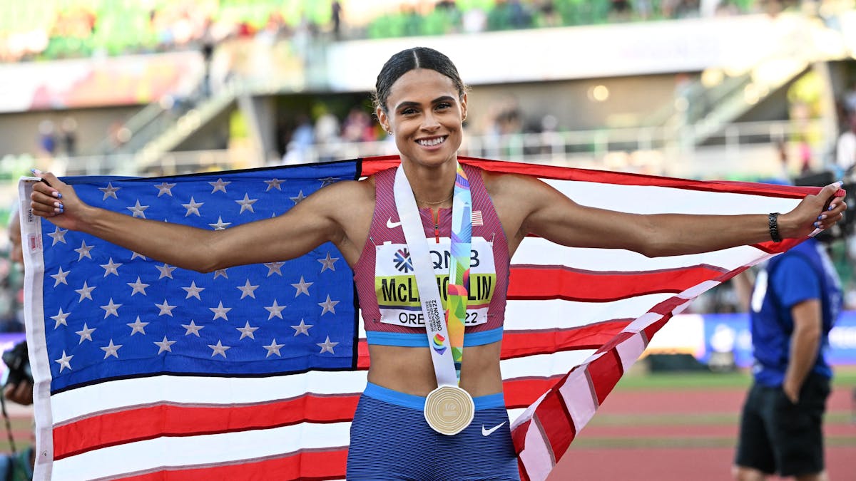 Sydney Mclaughlin posiet mit der US-Flagge und ihrer Goldmedaille.