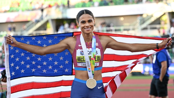 Sydney Mclaughlin posiet mit der US-Flagge und ihrer Goldmedaille.