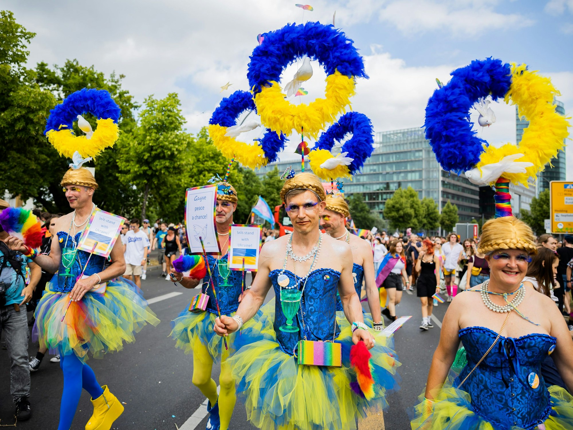 Teilnehmer und Teilnehmerinnen des CSD tragen Kostüme in den Farben der Ukraine.