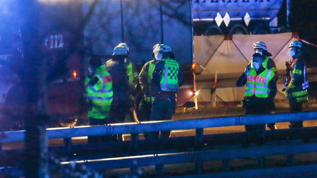 Feuerwehrleute und Polizisten stehen an der Autobahn 44 bei Aachen. Auf einem Rastplatz an der A44 ist ein 22-jähriger Belgier bei einem Unfall ums Leben gekommen.