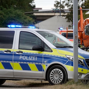 Ein Rettungshubschrauber und ein Polizeiauto stehen auf den Rheinwiesen in Düsseldorf. Während der Abbauarbeiten an der Düsseldorfer Rheinkirmes ist ein Mann von einem Fahrgeschäft gestürzt und hat sich schwer verletzt.