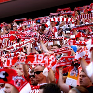 Fans des 1. FC Köln halten beim Testspiel gegen den italienischen Meister AC Mailand am 16. Juli 2022 Schals in die Höhe.