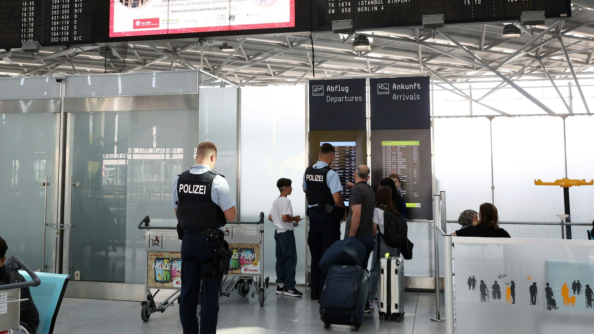 Lufthansa Streik am Flughafen Köln/Bonn. Reisende schauen auf eine An- und Abflugtafel.