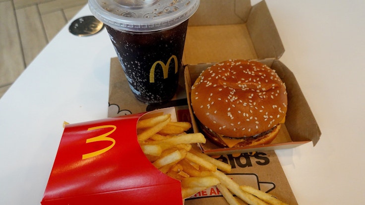A McDonald's burger, fries and drink on a table.