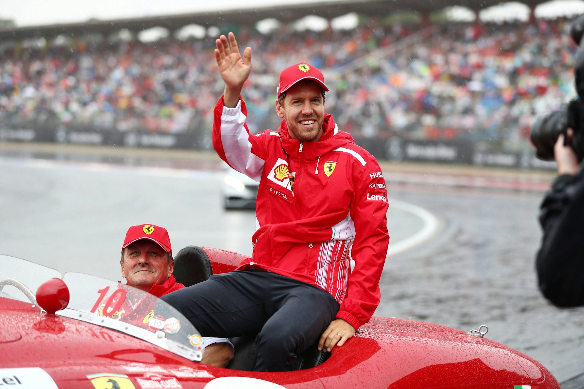 Sebastian Vettel winkt bei der Fahrerparade in Hockenheim den Fans zu.
