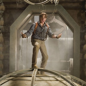 Brendan Fraser steht in einer Szene des Films „Die Mumie: Das Grabmal des Drachenkaisers“ auf einer Weltkugel.