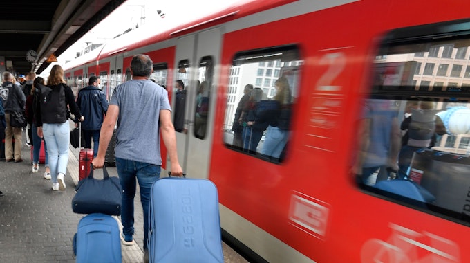 Bahnfahrer drängen sich am Eingang eines Regionalzuges am Deutzer Bahnhof.