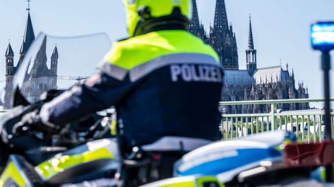 Ein Polizist fährt mit dem Motorrad über die Deutzer Brücke.