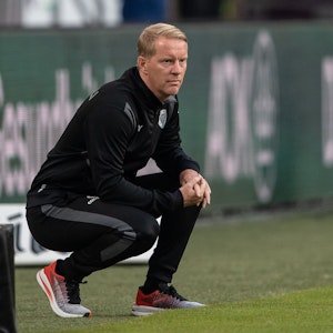 Timo Schultz geht bei einem Spiel des FC St. Pauli in seiner Coachingzone in die Hocke.