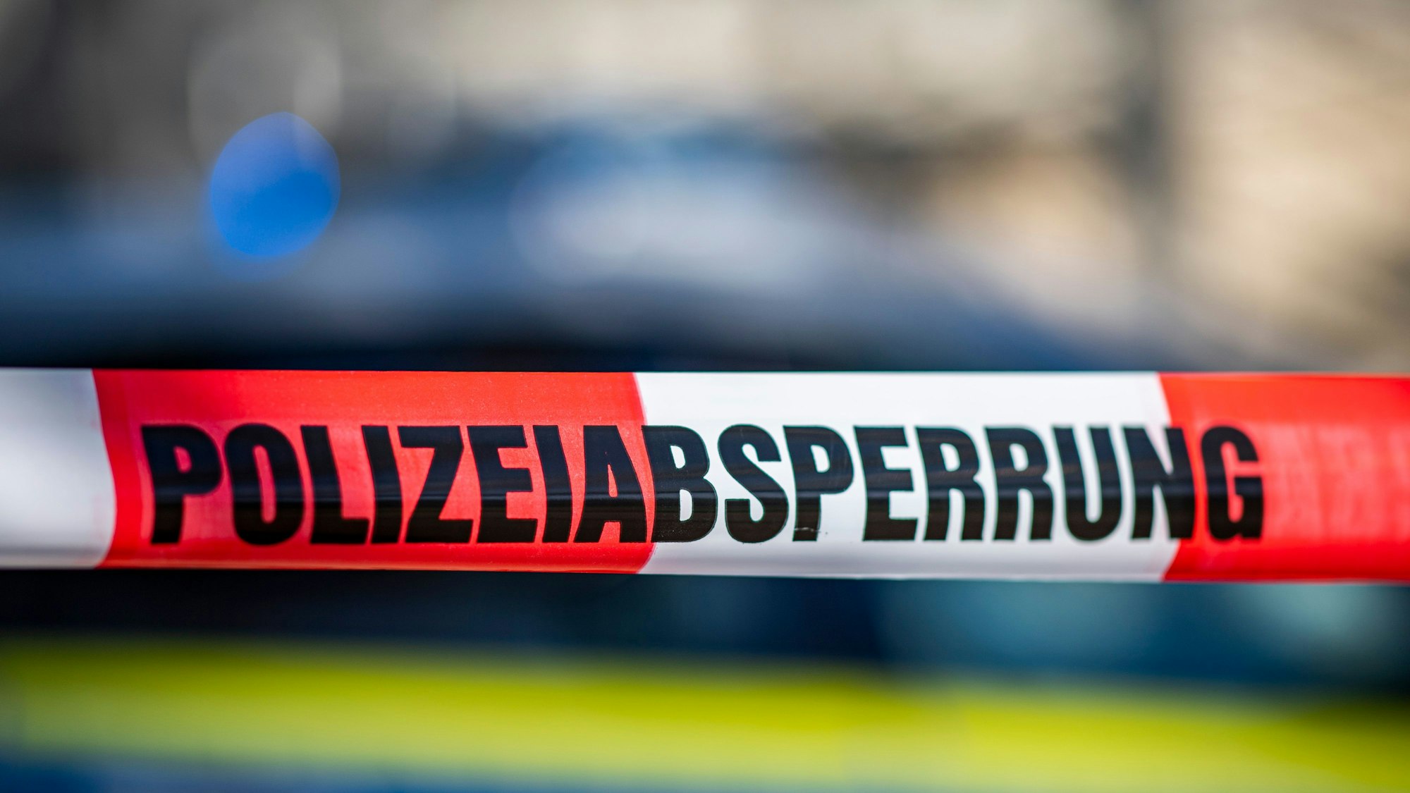 Die vermisste 14-Jährige aus Baden-Württemberg ist tot. Unser Symbolbild zeigt ein Absperrband mit der Aufschrift „Polizeiabsperrung“ ist vor einem Polizeiwagen.picture alliance/dpa