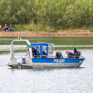 Ein Polizeiboot mit Tauchern der Taucheinheit Bochum ist auf einem Kiesteich in Porta Westfalica im Einsatz, an dem am Sonntag (24.07.2022) aus ungeklärten Gründen beim Baden zwei Personen nicht mehr aufgetaucht sind.