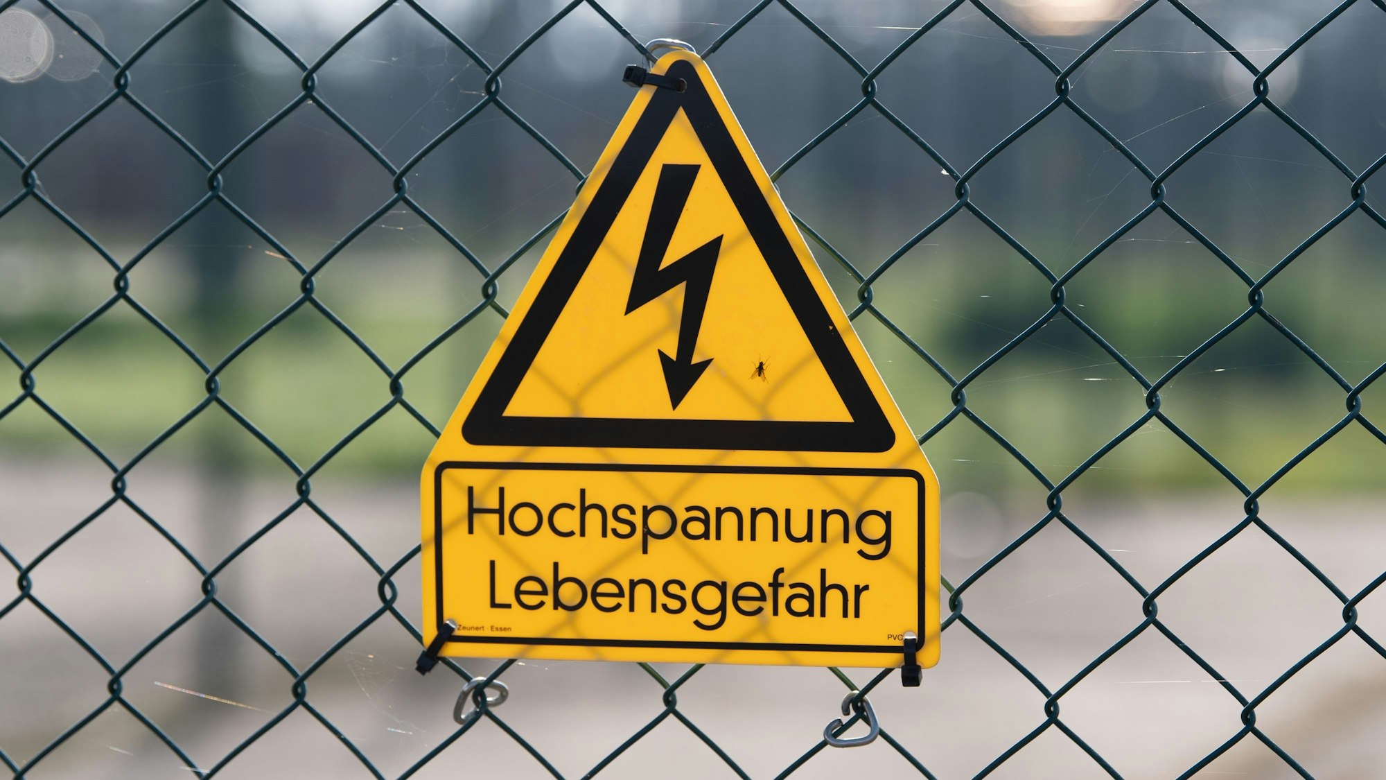 Ein Schild mit der Aufschrift „Hochspannung Lebensgefahr“ hängt an einem Zaun. In Levergusen-Opladen ist am Freitag der Strom ausgefallen.
