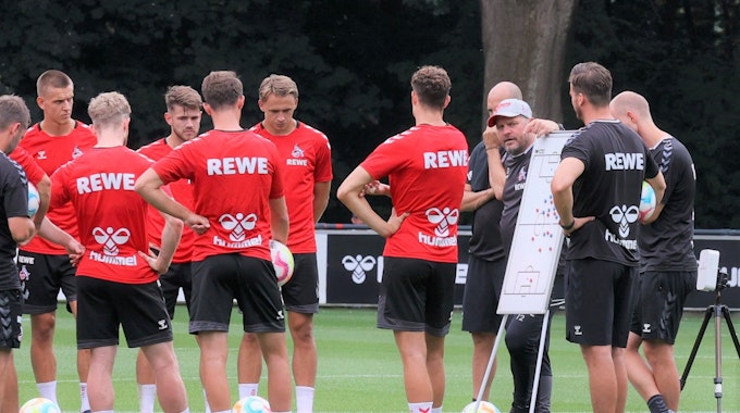 Steffen Baumgart spricht im Training des 1. FC Köln an einer Taktik-Tafel mit seiner Mannschaft