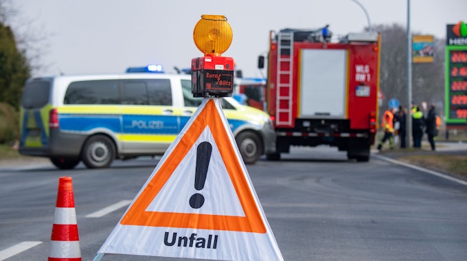 Ein Schild mit der Aufschrift Unfall sowie ein Polizei- und Feuerwehrfahrzeug stehen nach einem Unfall auf der Insel Usedom auf der Straße.