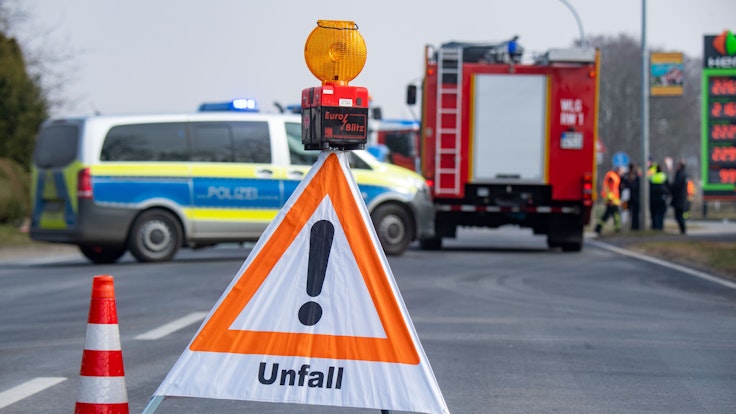 Ein Schild mit der Aufschrift Unfall sowie ein Polizei- und Feuerwehrfahrzeug stehen nach einem Unfall auf der Insel Usedom auf der Straße.
