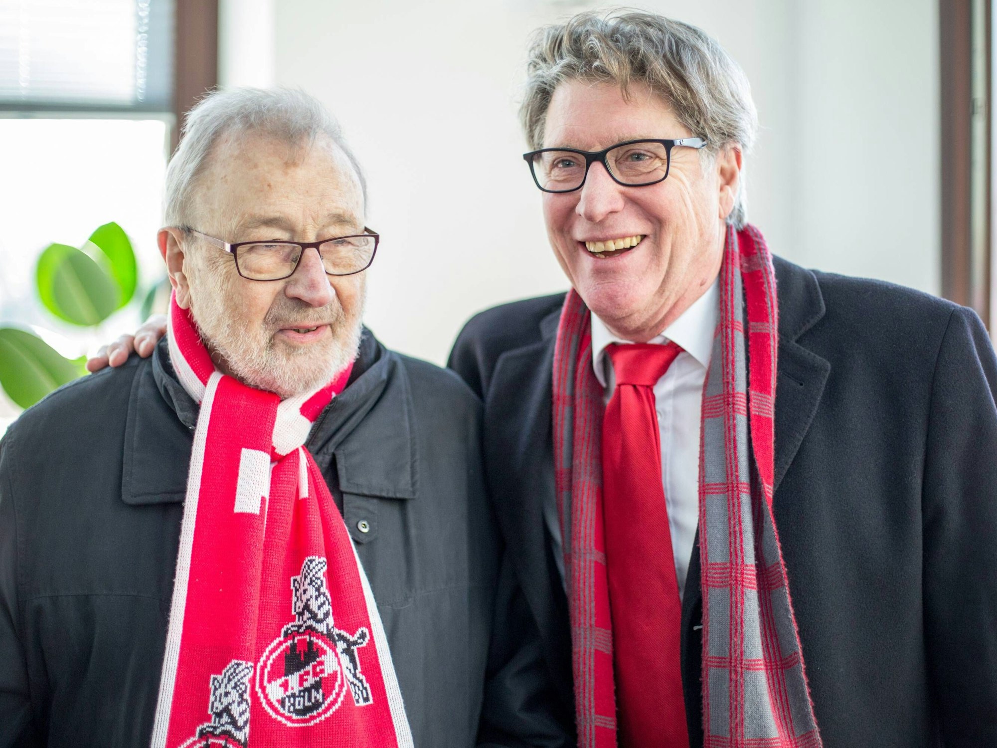 Max Esser trägt einen Schal des 1. FC Köln und steht neben Toni Schumacher.