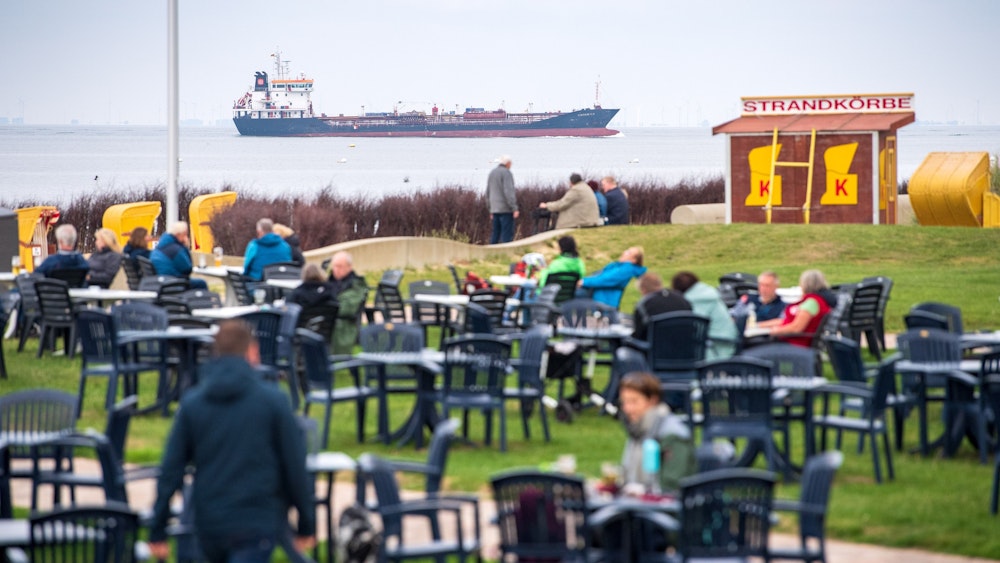 Ein Café macht an der Nordsee derzeit mit seiner knallharten Kinder-Maßnahme von sich reden. Urlauber sitzen in unserem Symbolbild (2021) vor einem Café am Strand von Cuxhaven. Es handelt sich hier nicht um das betroffene Café.