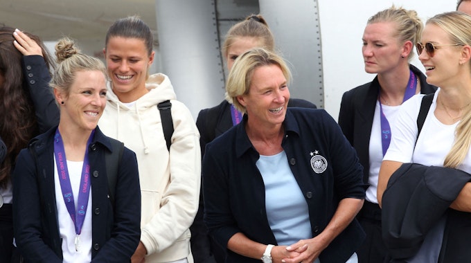 Svenja Huth, Martina Voss-Tecklenburg, Alexandra Popp, Merle Frohms und weitere Spielerinnen steigen aus dem Flugzeug.