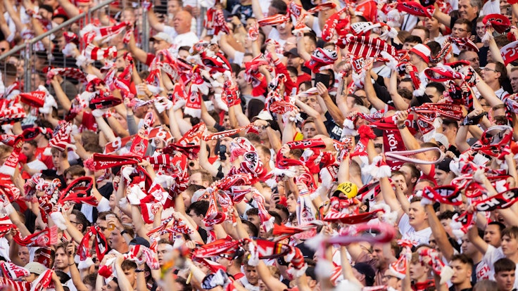 Fans des 1. FC Köln winken mit Schals.