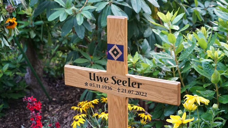Ein Holzkreuz steht auf dem Grab der Fußballlegende Uwe Seeler. Der beliebte Sportler wurde im engsten Familienkreis auf dem Friedhof Ohlsdorf beigesetzt.