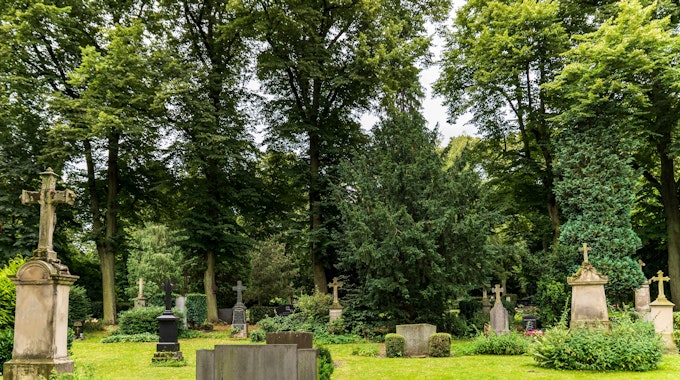 Blick auf eine Grünfläche mit Gräbern auf dem Melatenfriedhof in Köln.