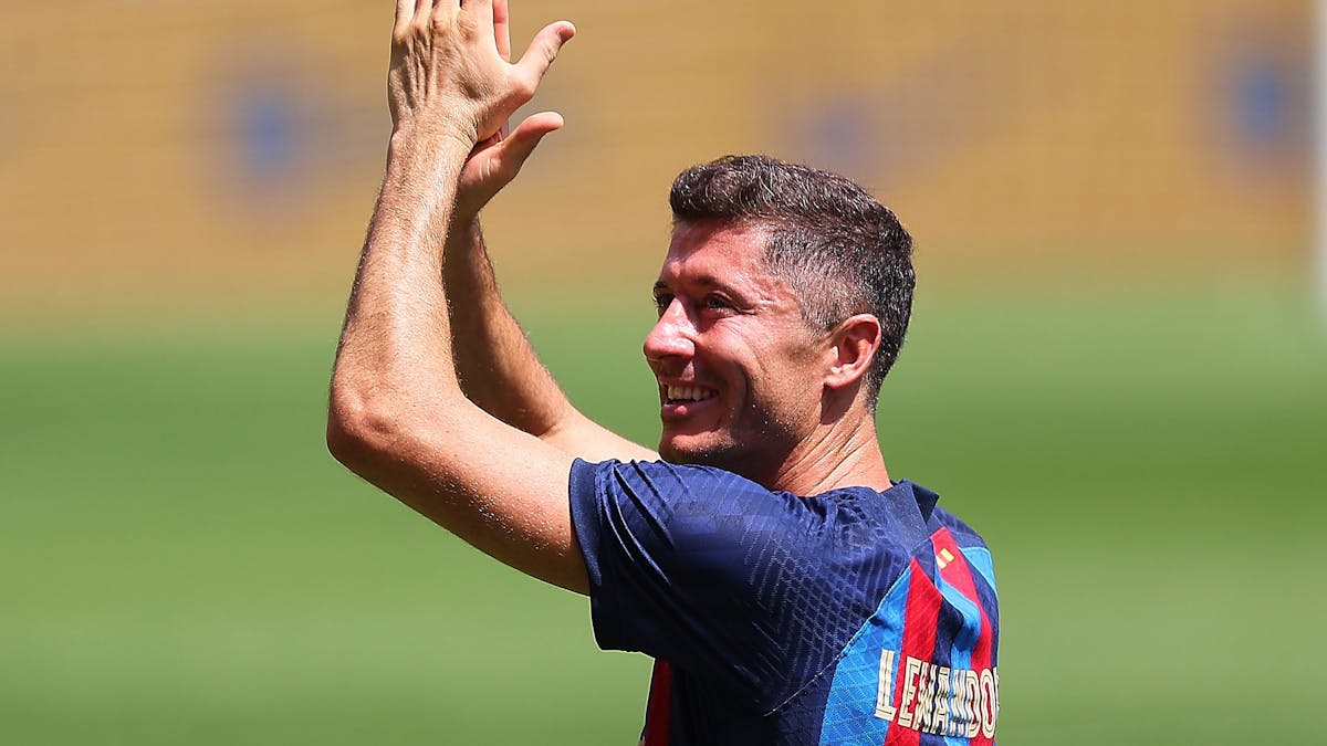 Robert Lewandowski klatscht bei seiner Vorstellung im Trikot des FC Barcelona im Camp Nou über dem Kopf in die Hände