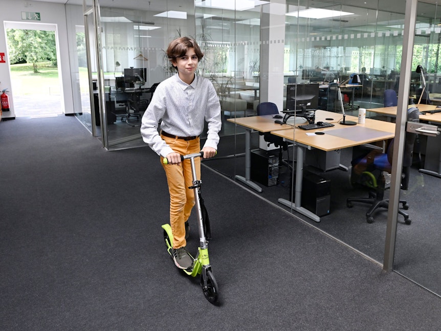 Ruben Charara fährt mit seinem Roller in einem Büro.